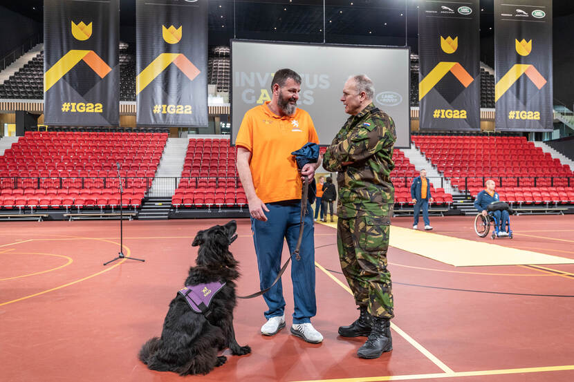 Commandant der Strijdkrachten Onno Eichelsheim in gesprek met een deelnemer met hulphond.