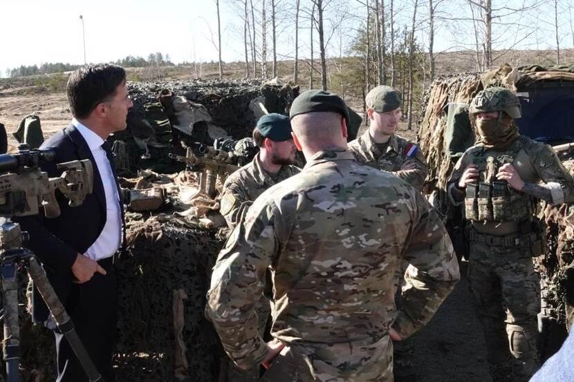 Premier Rutte staat met een groepje militairen.