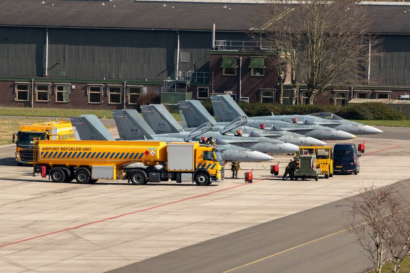 5 jachtvliegtuigen op een rij, ervoor staat een tankwagen.