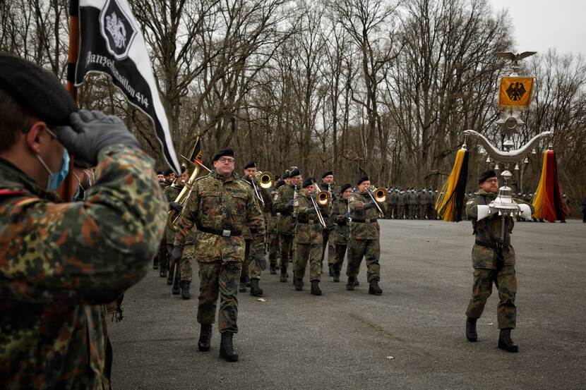 Militair muziekkorps marcheert over een binnenplaats.