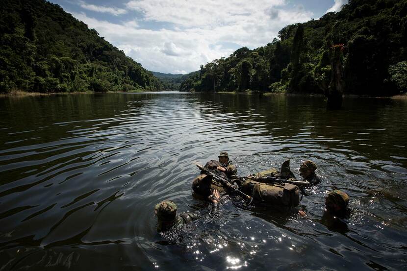 Militairen in een rivier in de jungle.