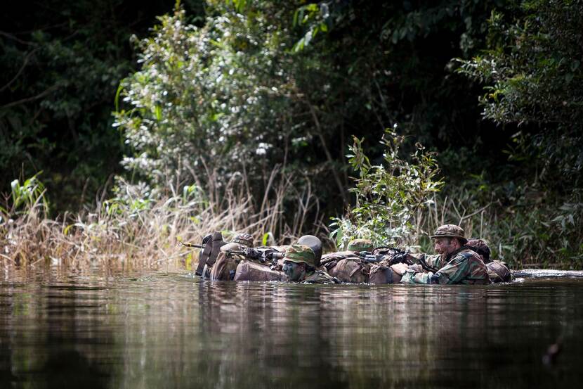 Militairen in een rivier in de jungle.