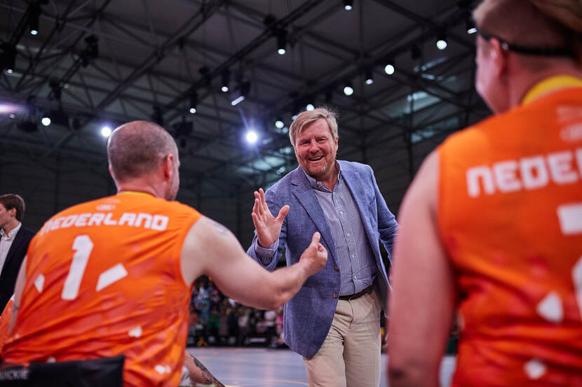 Koning Willem-Alexander feliciteert teamcaptain Wouter Bakker met het zilveren team rolstoelbasketbal.