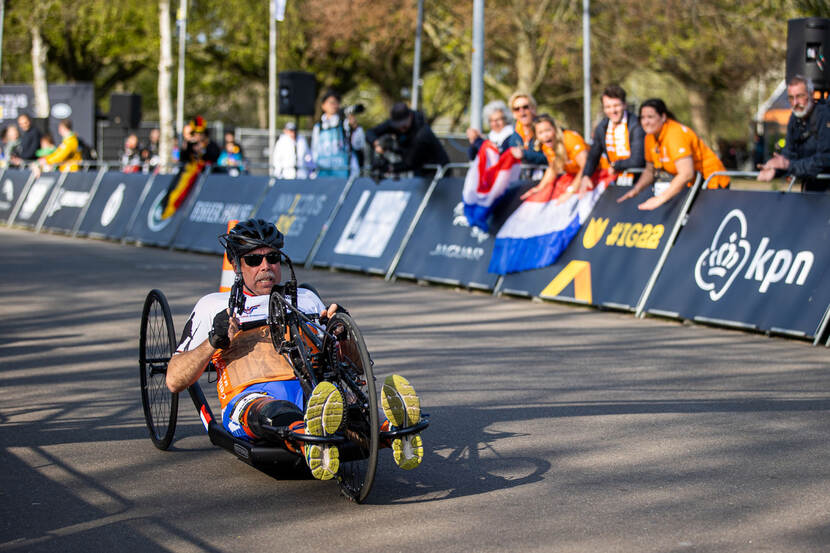 Handbiker en oud-landmachtmilitair Robert Konter tijdens zijn wedstrijd, publiek moedigt hem aan.