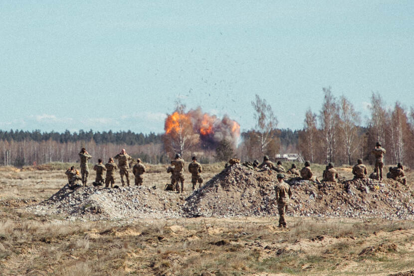 Grote explosie. Militairen kijken er van afstand naar.