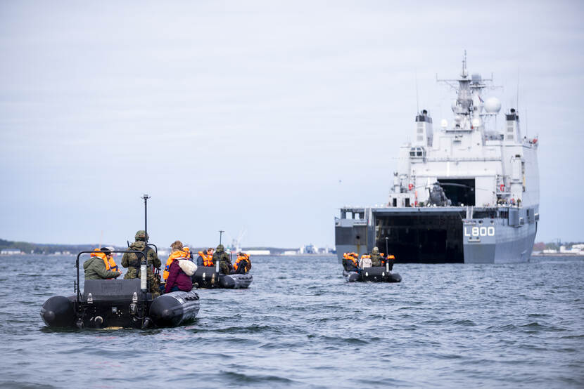 Rubberboten varen achter marineschip Zr.Ms. Rotterdam.