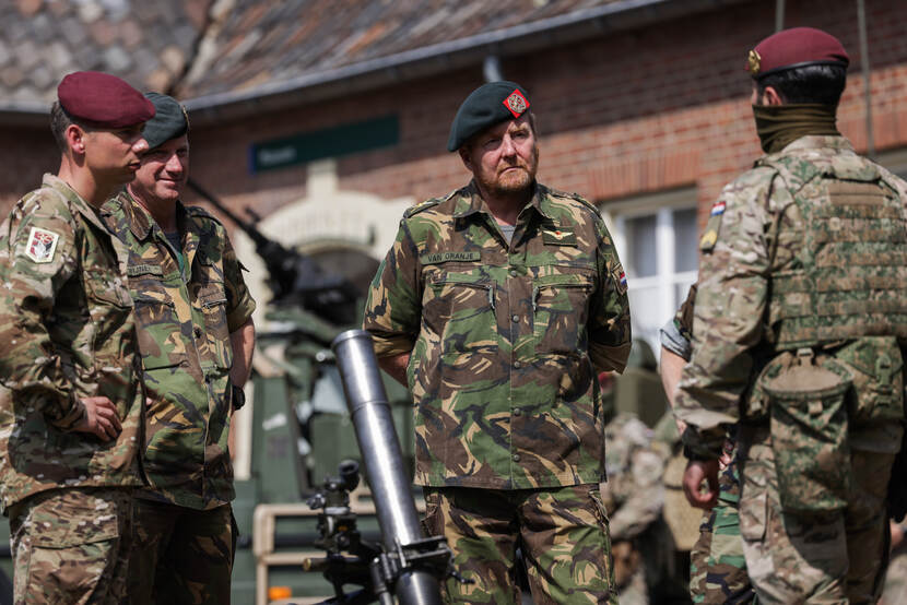 De koning in gesprek met militairen.