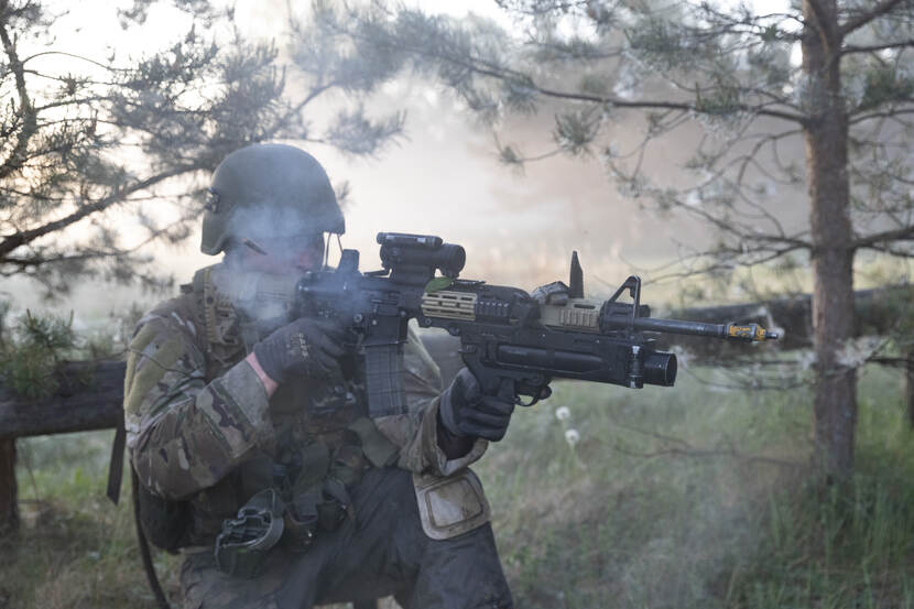 Militair met wapen in zijn handen. Rook om zijn hoofd.