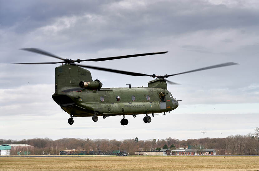 Een Chinook-transporthelikopter vlak boven de grond.