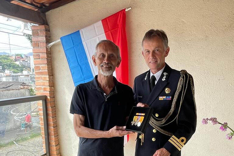 De Nederlandse Defensieattaché voor Brazilië Jaap Hubbelmeijer reikt de onderscheidingen uit aan de zoon van oud-KNIL-militair Carel Marie Fredriksz.