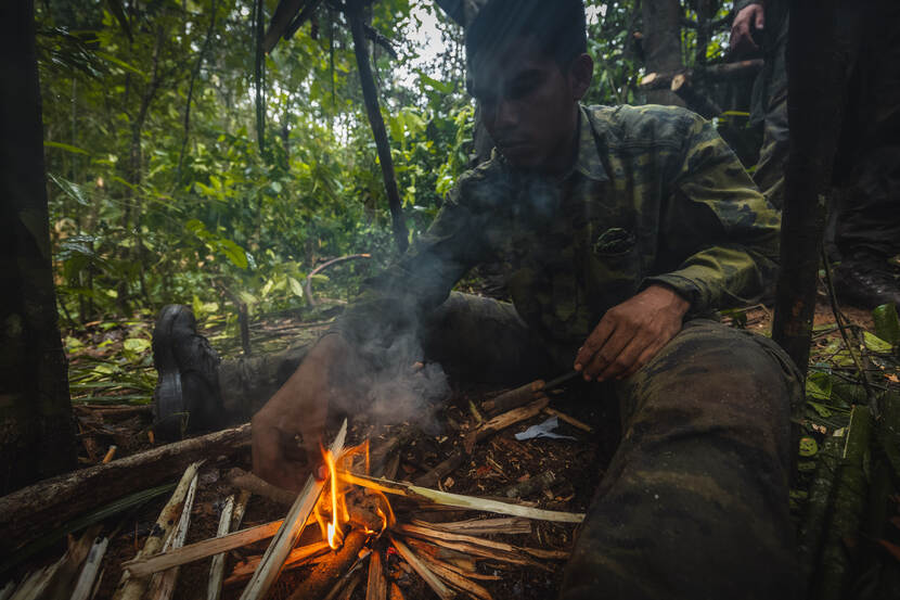 Militair bij een vuur in de jungle.