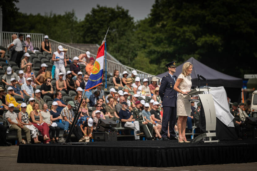 Minister Ollongren achter spreekgestoelte, toehoorders op een tribune achter haar.