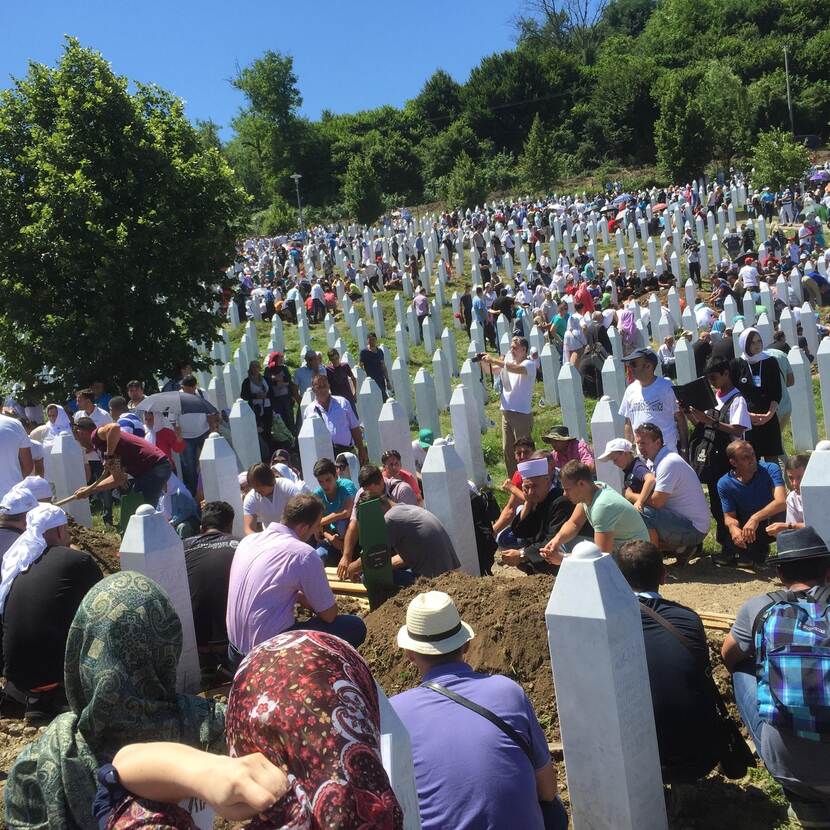 Archieffoto van een begraafplaats in Srebrenica waar nabestaanden treuren om in 1995 vermoorde jongens en mannen.