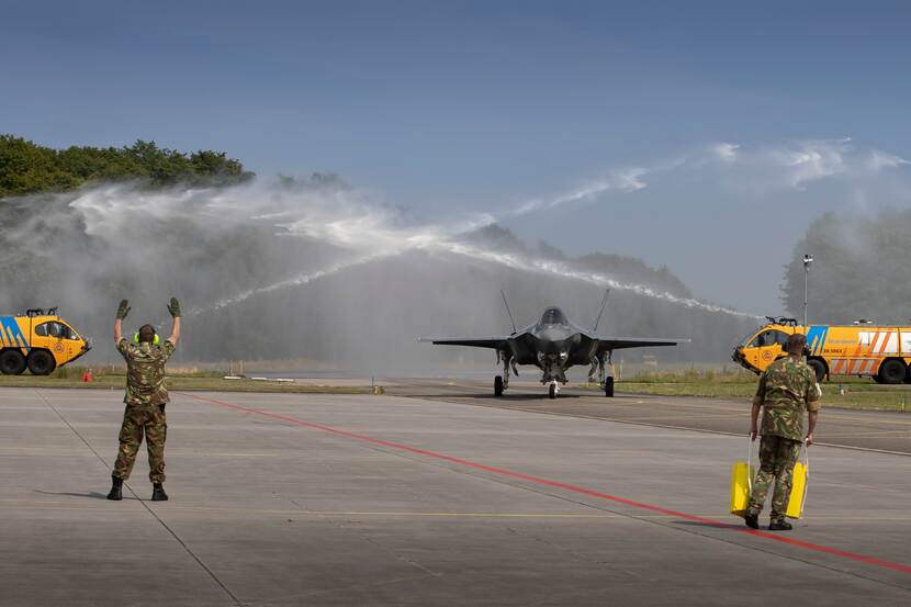 F-35 wordt met water uit blusvoertuigen onthaald op zijn nieuwe basis.