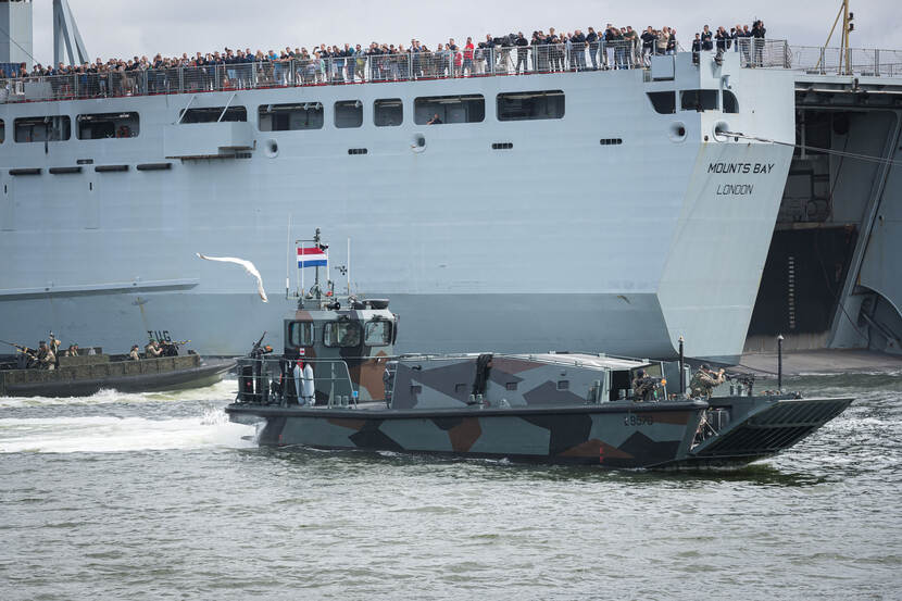 Bezoekers kijken vanaf het Britse landing ship dock Mounts Bay naar een demonstratie.