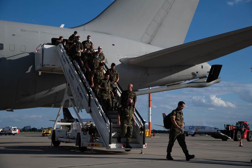 Militairen verlaten een vliegtuig via een trap.