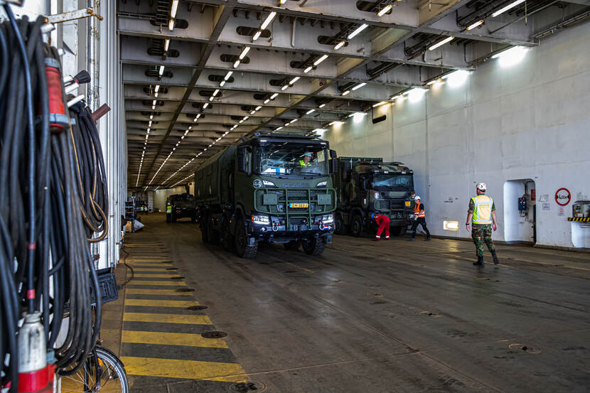 Militairen voertuigen in een schip.