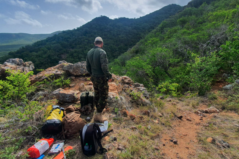 Militair met materialen in natuurgebied.