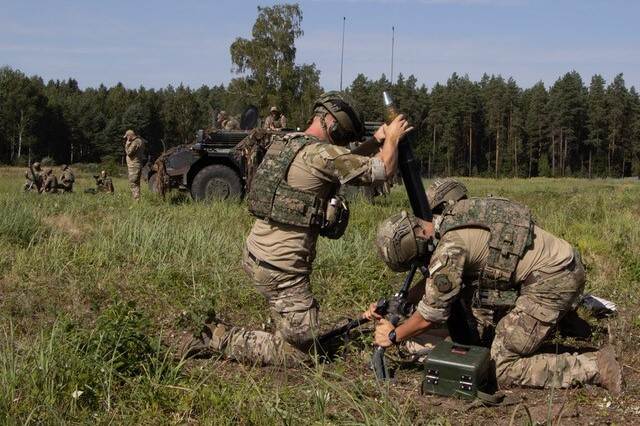 Militairen bezig met een opstelling in het veld.