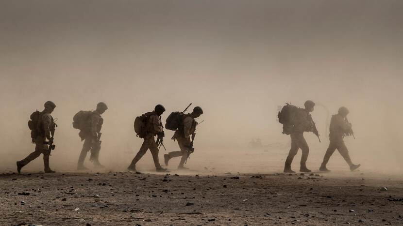 Archieffoto: militairen met volle bepakking lopen over zandvlakte.