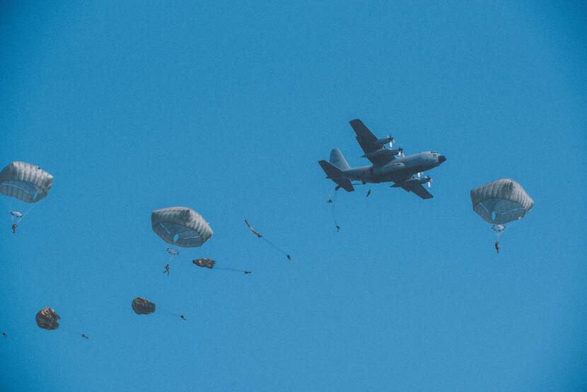 Parachutisten van 11 Luchtmobiele Brigade springen uit een C-130 Hercules-transportvliegtuig.