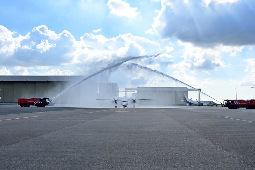 2 E-One Titan-crashtenders verwelkomen de Dash-8 met een waterdouche.