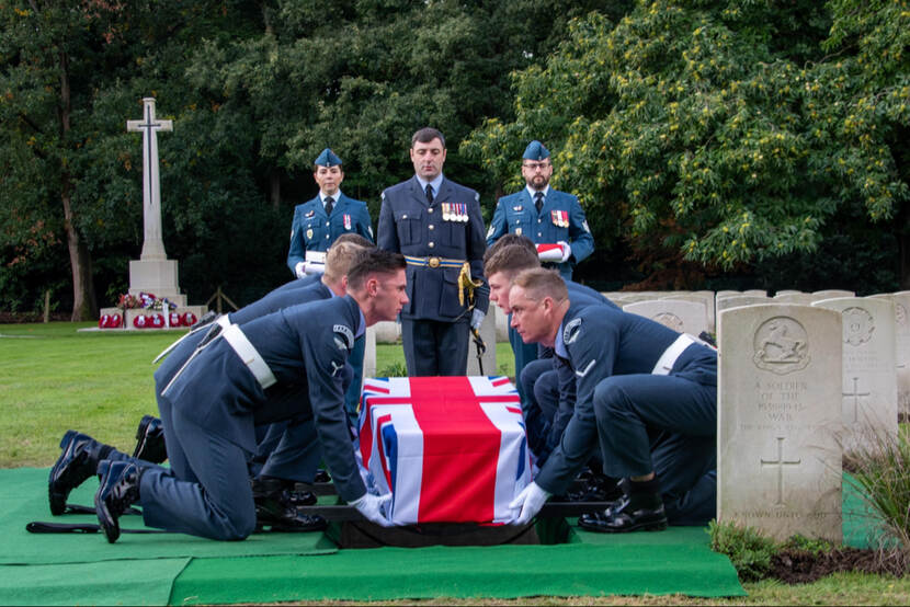 Britse militairen laten kist met Britse vlag in graf zakken.