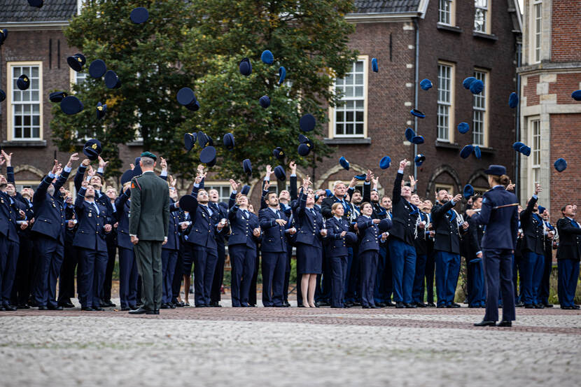 Het ‘pettenmoment’. Op commando gooien de voormalige cadetten hun pet of baret in de lucht.