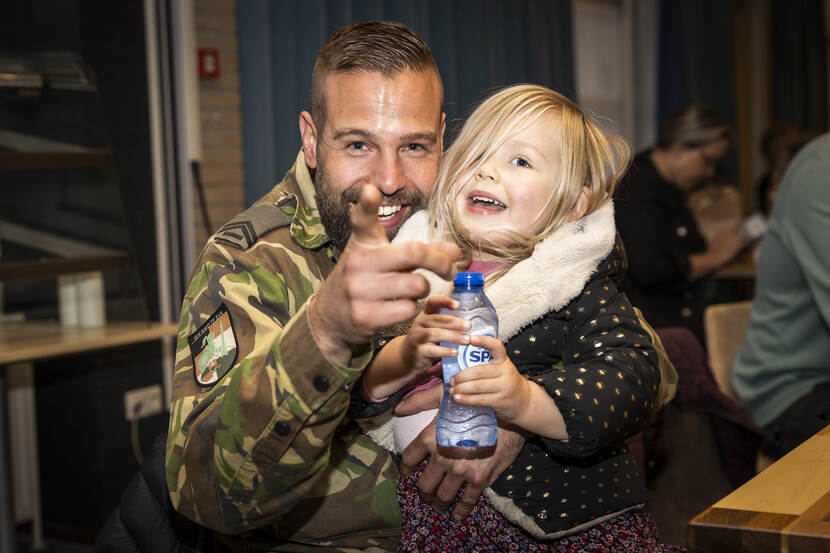 Thuisgekomen militair met meisje.