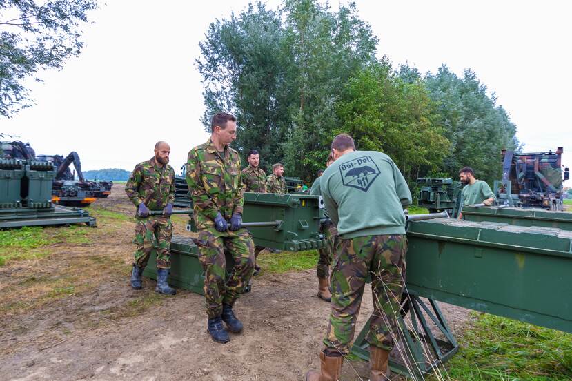 Militairen leggen een noodbrug aan.