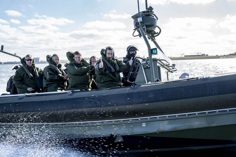 De Zweedse generaal Micael Bydén vaart mee in snelle motorboot en steekt zijn duimen omhoog.