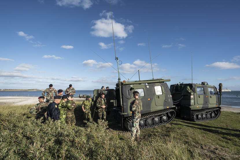 Mariniers en amfibische landingsvoertuigen op het strand.