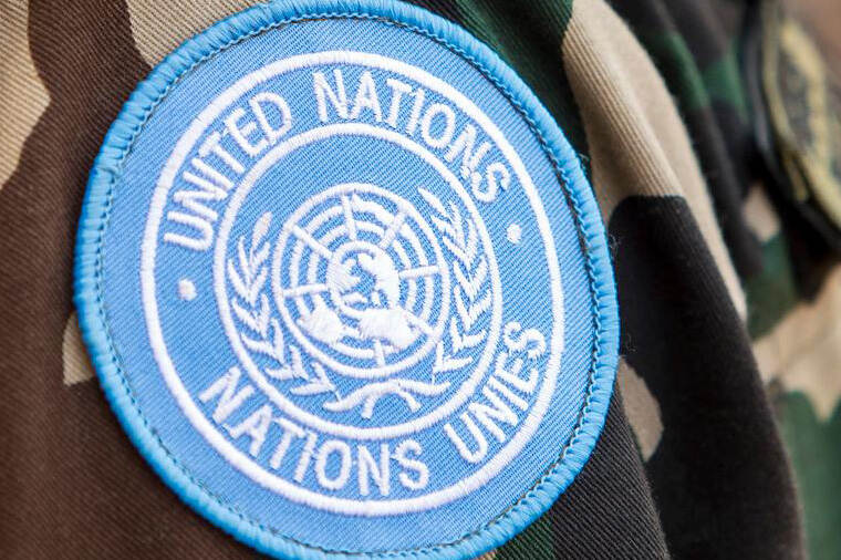VN-badge met de tekst: United Nations, Nations unies.