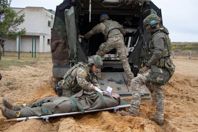 Militair ligt op een brancard voor open voertuig.