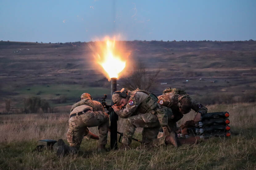 Militairen vuren een wapen af.