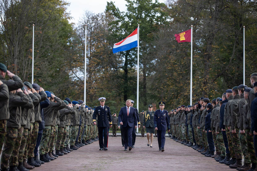 Koning Willem-Alexander, luitenant-generaal Verbeek en generaal-majoor Oppelaar lopen door een haag van saluerende militairen.