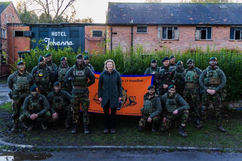 De minister poseert met militairen.