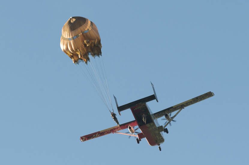 Een militair is net uit een vliegtuig gesprongen bij het testen van nieuwe parachutes.