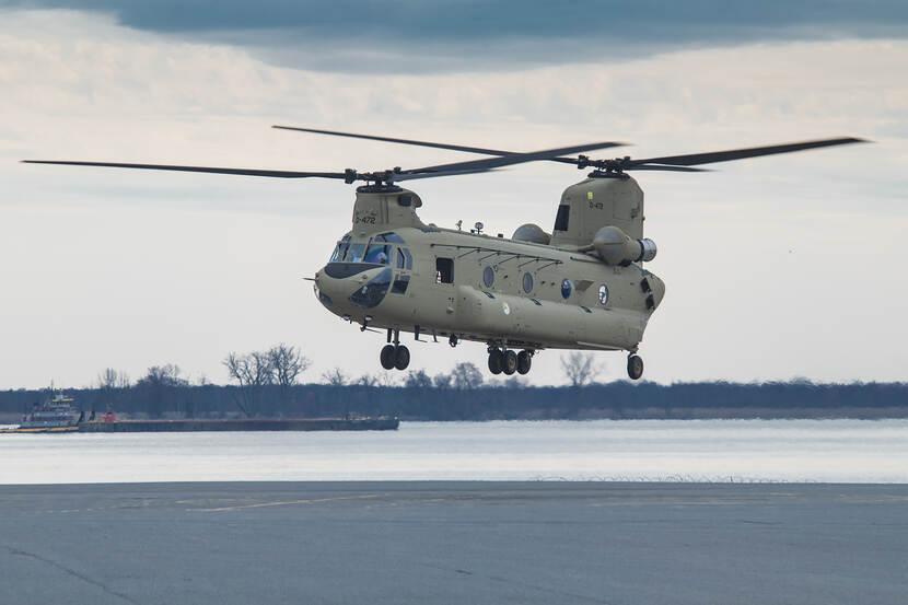 De CH-47F MYII CAAS laag boven de grond vliegend.