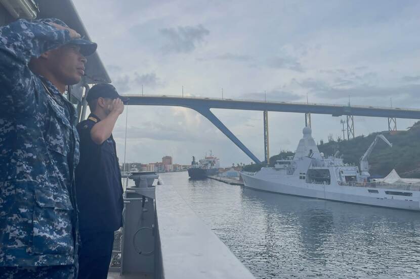 Een Nederlands en een Surinaamse militair salueren op de Pelikaan naar een patrouilleschip in de haven van Willemstad tijdens een eerdere uitwisseling.