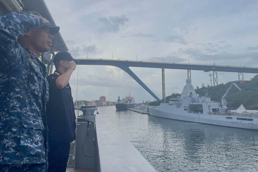 Een Nederlands en een Surinaamse militair salueren op de Pelikaan naar een patrouilleschip in de haven van Willemstad tijdens een eerdere uitwisseling.