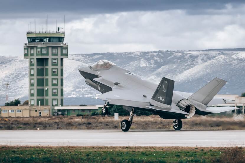 F-35 stijgt op. Besneeuwde bergen op de achtergrond.