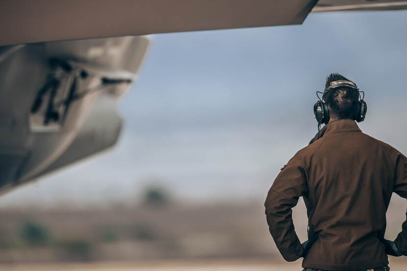 Militair met headset staat naast F-35.