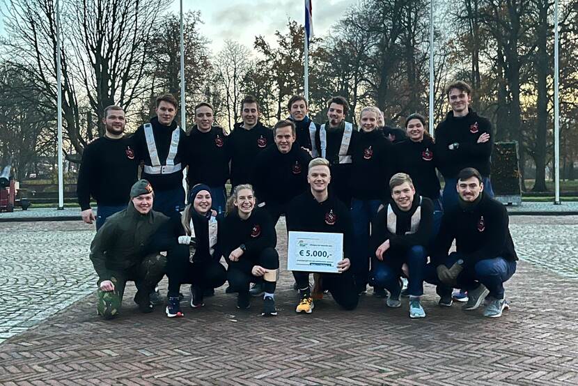 Groep cadetten. Voorste heeft cheque met € 5.000 in handen.