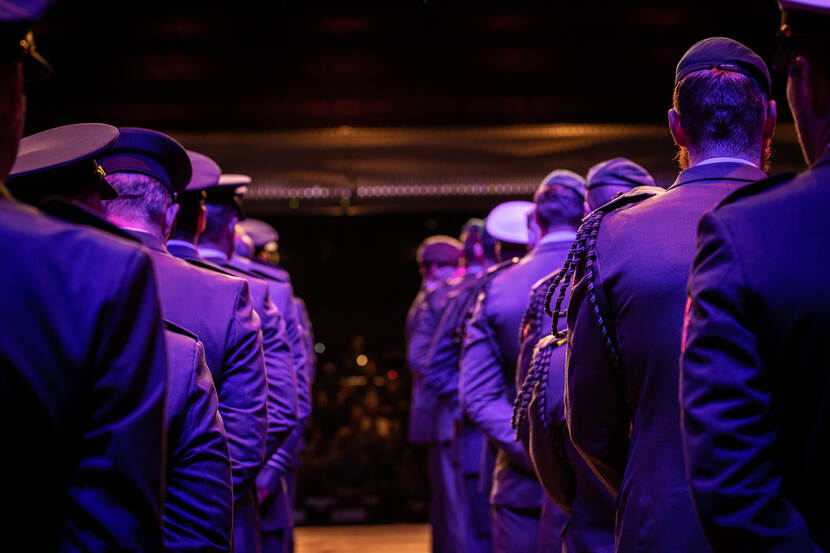 Militairen in het gelid van achteren bezien, wachtend op de uitreiking van de de herinneringsmedaille.