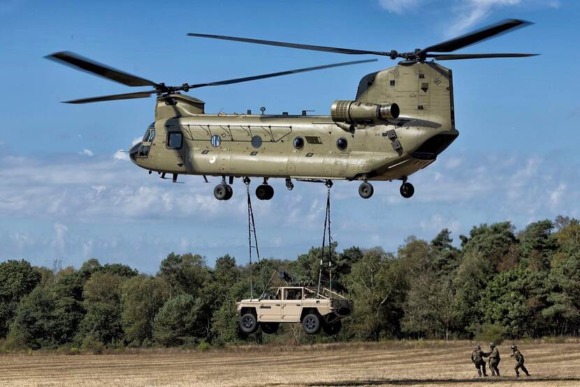 Een Vector hangt onder een Chinook-transporthelikopter.