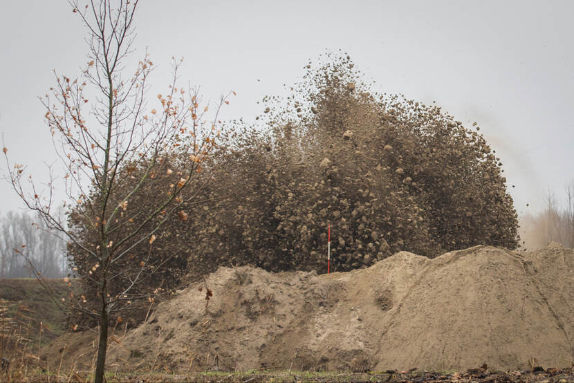 Ontploffing. Berg zand op voorgrond.