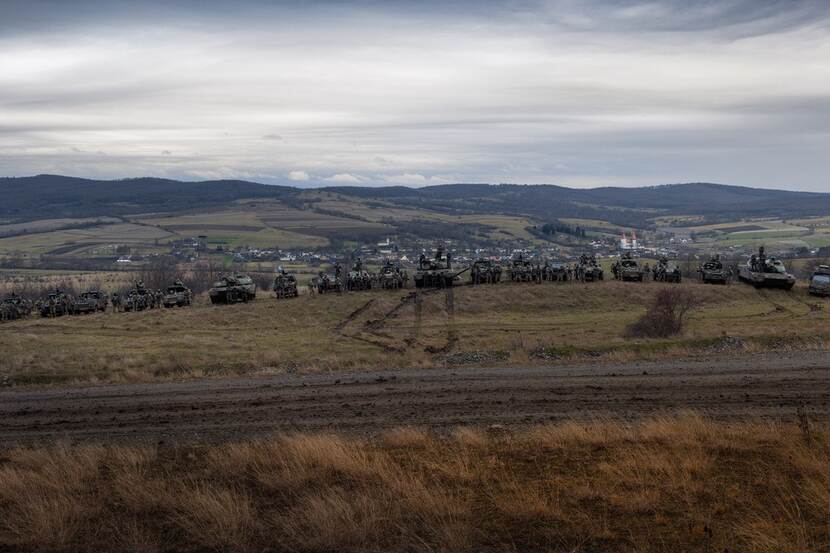 Tanks op een rij in weids landschap.