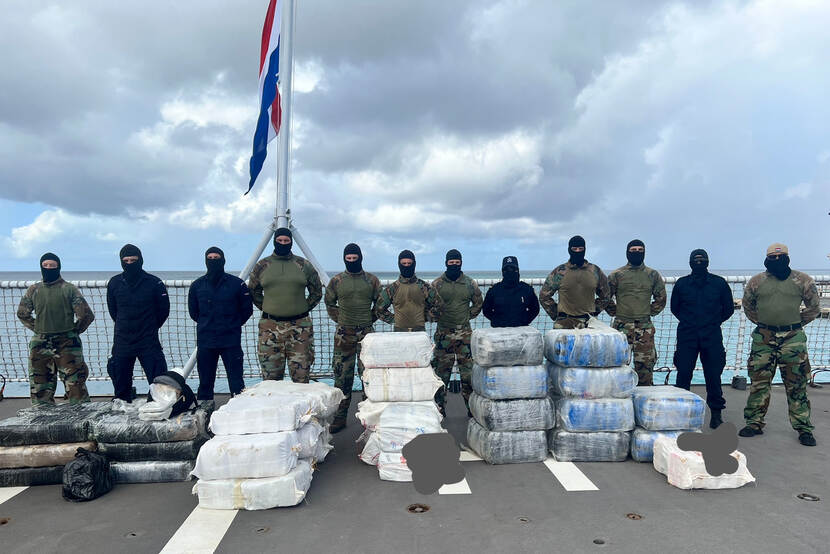 De onderschepte drugspakketten op achterdek Zr.Ms. Holland. Met militairen erachter.