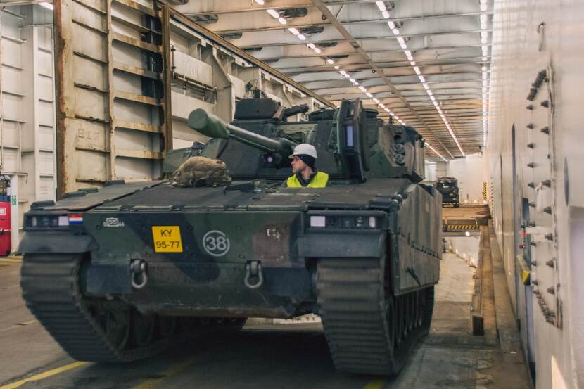 CV90-gevechtsvoertuig met militair rijdt van schip.